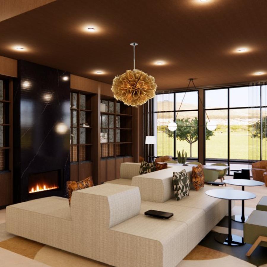 a clubroom with a couch, tables, chairs and a fireplace